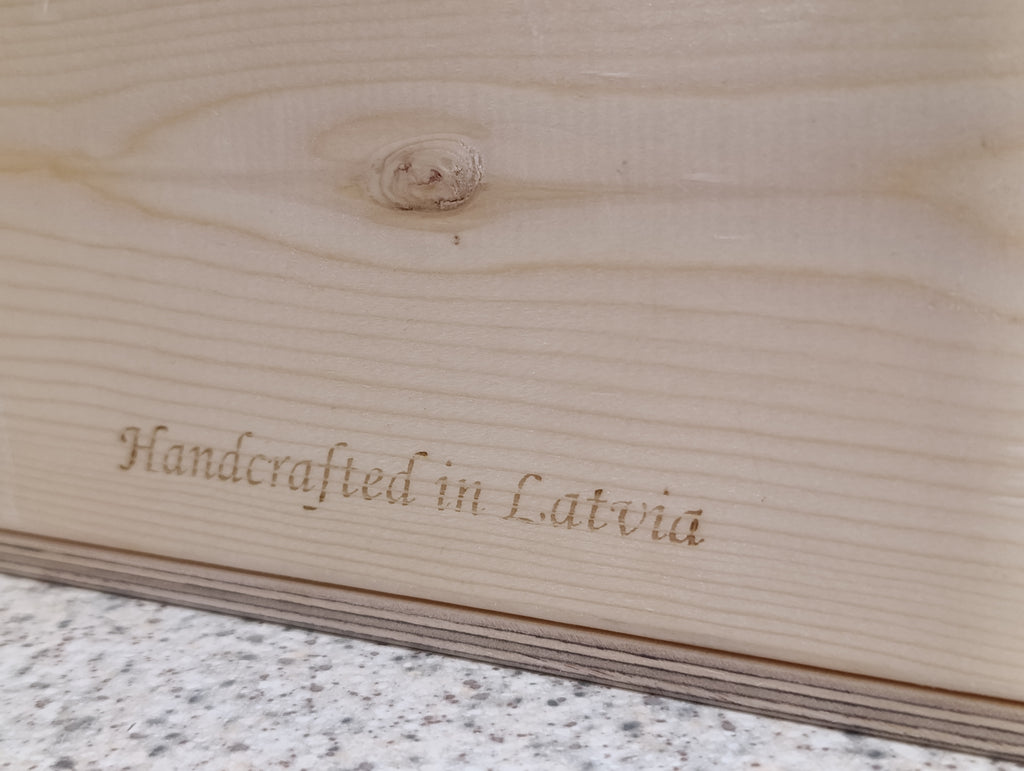 Wooden surface with 'Handcrafted in Latvia' engraving