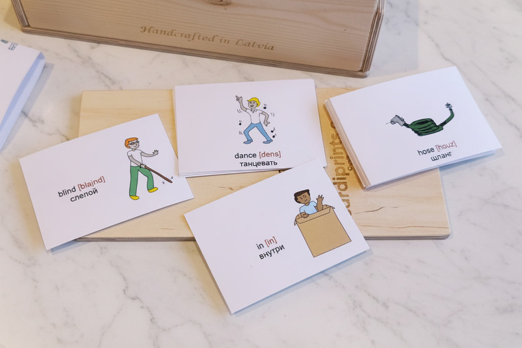 Educational flashcards with illustrations and text on a wooden box and countertop.